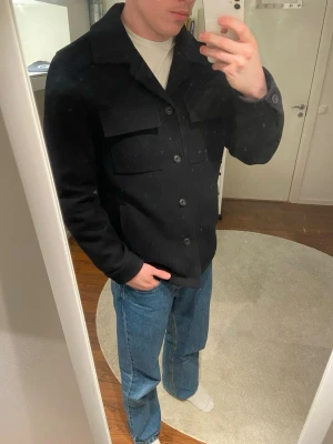 Mango vårjacka strl M - En stilren vårjacka från Mango i mycket bra skick. Jackan har även en luva som man kan fästa på jackan. Nypris: 1300kr. Levereras inom en till två dagar. Kontakta mig om du har frågor!