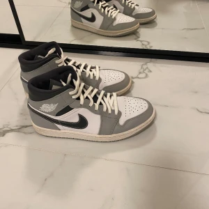 Air Jordan 1 Mid ’Light Smoke Grey’ - Nästintill oanvända. Jag köpte skorna för ett tag sedan på Nikes egna hemsida, men har nog inte använt mer än 3 gånger. Skriv för att förhandla pris!  