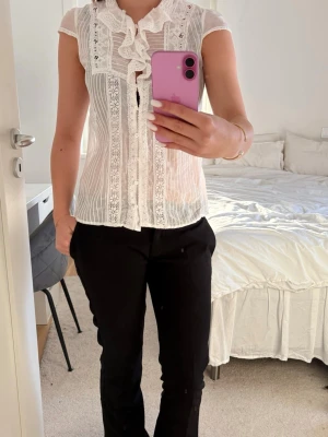 Vit blus  - En vit spetsblus med kort ärm från MassimoDutti i storlek XS/S. Blusen knäpps med knappar framtill och alla knappar sitter kvar. 