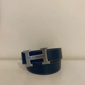 Blå skinnbälte med H-spänne - Snabb frakt – skickas direkt efter köp! Produkten är helt ny, aldrig använd. Tillverkad i bästa kvalitet på marknaden. Perfekt skick och redo att användas, Längd 110cm