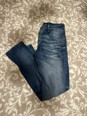 Blå comfort fit jeans från Jack & Jones - Säljer ett par blå jeans från Jack & Jones i modellen Comfort Fit Mike. Jeansen har klassisk femficksdesign, normal passform och raka ben. Materialet är slitstarkt denim med snygga tvättade detaljer. Perfekt för dig som gillar avslappnad stil.