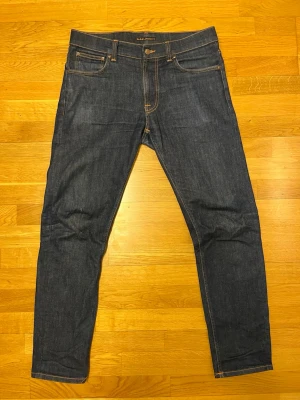 Nudie Jeans Lean Dean - Säljer ett par dry jeans från Nudie Jeans med storleken 34w och 32l. Modellen är lean Dean och är slim fit och har zip gylf. Jeansen är får en go fade desto mer man använder dem. Skriv gärna ifall ni undrar något :)