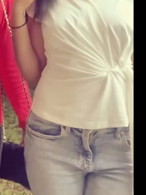 Vit omlottopp med knutdetalj - Säljer en vit omlottopp med snygg knutdetalj i sidan. Toppen har v-ringad hals och är ärmlös, vilket ger en fräsch och modern look. Tillverkad i ett mjukt och stretchigt material som känns skönt mot huden. Perfekt att styla med jeans eller kjol. den är i storlek S men passar XS 