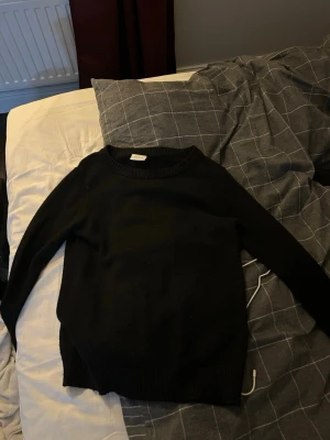 Svart stickad tröja från Vila - En klassisk svart stickad tröja från Vila i storlek XS. Tröjan har rund halsringning, ribbade muddar och lång ärm. Perfekt basplagg till garderoben och enkel att matcha med olika stilar.