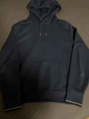 Fred perry hoodie - En mörkblå snygg fred perry hoodie i storlek Medium. Knappt använd och inga tecken på slitage.