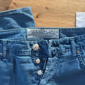 Blå jeans från Jacob Cohen - Snygga blå jeans från Jacob Cohen med klassisk femficksdesign och knappgylf.  Modellen är 622.