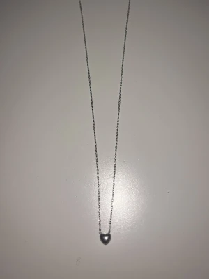 Halsband Edblad - Bilderna visar ett halsband i silver med ett hjärtformat hänge och en tunn kedja. Superfint och nästan aldrig använt. Köpt från Edblad - nypris 249kr.🥰