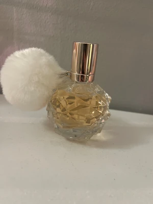 Söt parfym, Ariana Grande - Trendig parfym från Ariana Grande med en unik kristallformad flaska och en fluffig vit boll. Volym: 30 ml (1.0 fl oz). Endast testad 3-5 gånger💗