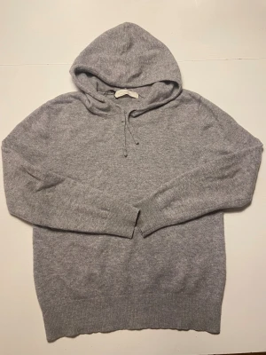 Grå cashmere hoodie från Sayless XS - Supermjuk och lyxig grå hoodie från Sayless i äkta cashmere. Tröjan har huva med snörning, ribbade muddar och långärmad design. Perfekt för dig som vill ha en chill och stilren look med premiumkänsla.