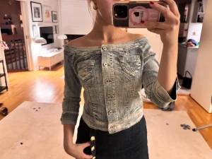Super snygg offshoulder topp i jeans! - Säljer denna unika offshoulder denim topp med ljusblå tvätt. Den har cirka trekvartslånga ärmar och knappar fram till. Även jätte snygg jeanstvätt och mönster på fickorna❤️❤️