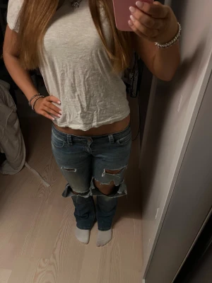 lågmidjade jeans - Supersnygga och coola lågmidjade jeans med hål. Strl s. Jag är ca 165 lång. Kom privat för fler bilder eller frågor❤️❤️