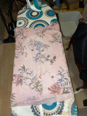 Blommiga ljusrosa linne blus - Säljer en ljusrosa blus med blommigt mönster i lila blått och grönt. Blusen har en snörning och är tillverkade i en luftig mix av bomull och linne. Perfekta för dig som gillar chill och färgglada vibes.