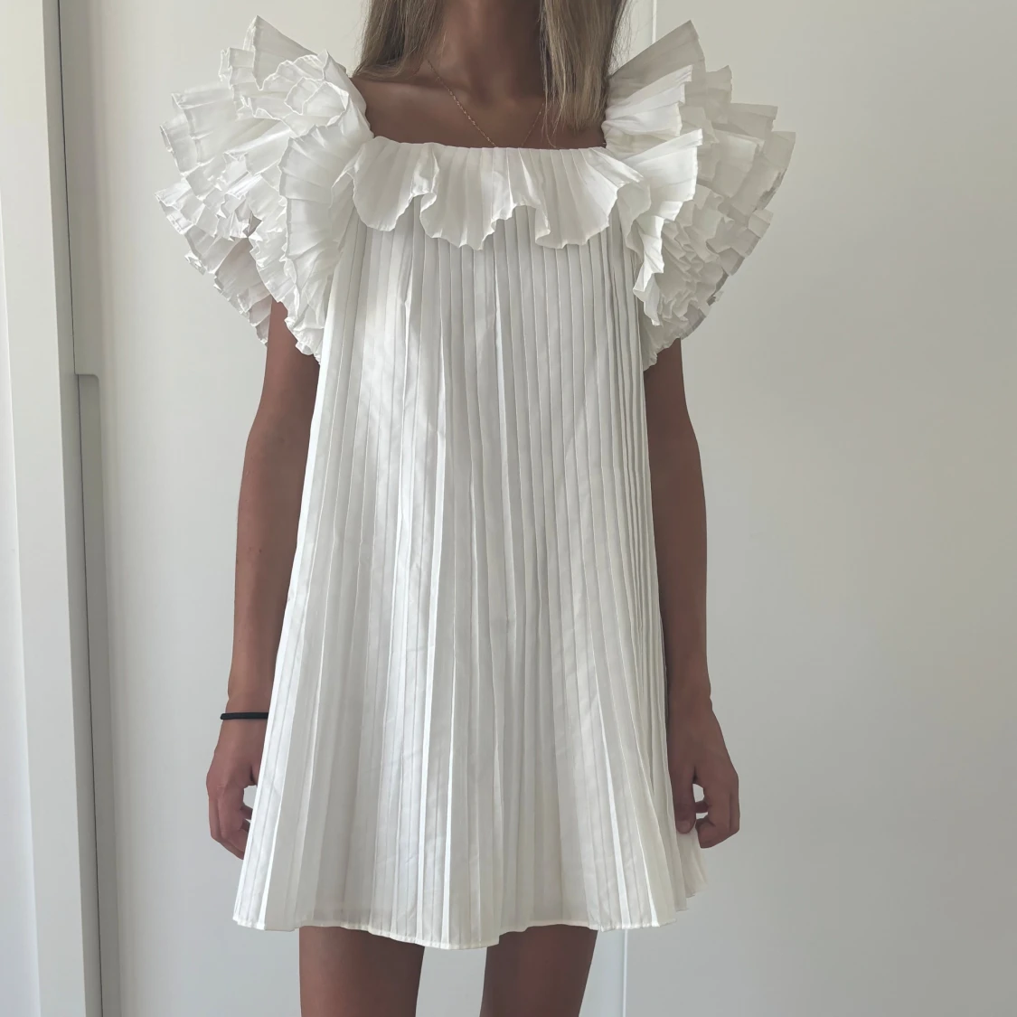 Vit plisserad volangklänning