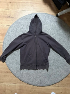 Svart hoodie från Polo Ralph Lauren - Svart hoodie från Polo Ralph Lauren med broderad logga på bröstet. Tröjan har huva med snörning, dragkedja framtill och två fickor. Tillverkad i mjuk bomull och har långärmad passform. Perfekt för chill dagar och streetwear.