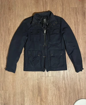 J Lindberg field jacka  - Snygga jacka i storlek M en av knapparna på en av fickorna har ramlat av 