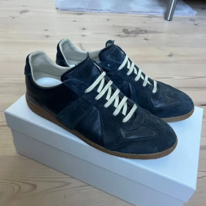 Maison Margiela Gats - Mörkblå masion margiela gats i bra skick där bild på kvitto finns men inte fysiskt, allt ingår dustbag och låda, tveka inte på att höra av dig vid frågor 