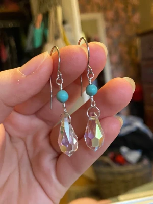 Hängande örhängen med turkos pärla - Snygga örhängen med silverfärgad krok, rund turkos pärla och droppformad, facetterad kristall som reflekterar regnbågens färger. Perfekt för dig som gillar unika och glittriga accessoarer med boho-vibe.