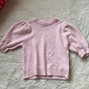 Ljusrosa stickad tröja från Gina Young💗 - Supersöt ljusrosa stickad tröja från Gina Tricot med puffiga kortärmar och ribbade muddar. Tröjan har rund hals och är i mjukt material som känns skönt mot huden. Perfekt för dig som gillar gulliga och trendiga detaljer. Tröjan sticks inte💗!