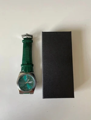 Poedagar Herrklocka turkos Quartz 41mm läderarmband  - Snygg klocka från Poedagar med grön urtavla och matchande grönt armband i skinn med krokodilstruktur. Boetten är i silverfärgad metall och har en klassisk rund form med dag- och datumvisning. Perfekt accessoar för dig som vill sticka ut med stil.