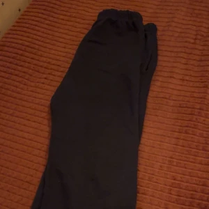 Mörkblå mjukisbyxor med resårmidja - Mysiga mörkblå mjukisbyxor med resår i midjan och mjuk fleece på insidan. Perfekta för chill eller träning, med enkel design och bekväm passform. Snygga att matcha med hoodie eller t-shirt.