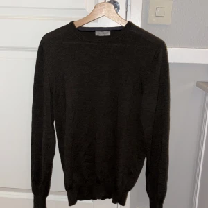 Mörkgrön ulltröja Gran Sasso - Snygg mörkgrön tröja från Gran Sasso, tillverkad i Italien av 100% ull. Klassisk rund hals och långärmad modell med ribbade muddar vid ärmslut och nederkant. Perfekt för dig som gillar stilrena och tidlösa plagg.