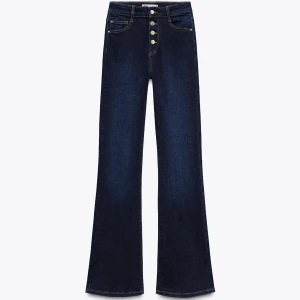 Mörkblå bootcut jeans med knappar - Snygga mörkblå jeans med bootcut passform och hög midja. Jeansen har fyra silverfärgade knappar framtill och klassiska fickor både fram och bak. Materialet är jeans med lite stretch för skön passform. Perfekta för dig som gillar en trendig och bekväm stil.