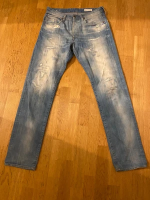 G-Star raw jeans - Säljer ett par G-Star Raw 3301 jeans i ljusblå tvätt med slitna detaljer och distressed look. Modellen är tapered med normal passform och klassisk femficksdesign. Inte används alls många gånger!! Max 10 gånger har dom används. Storleken är W32 och L34! Öppen för pris förslag!