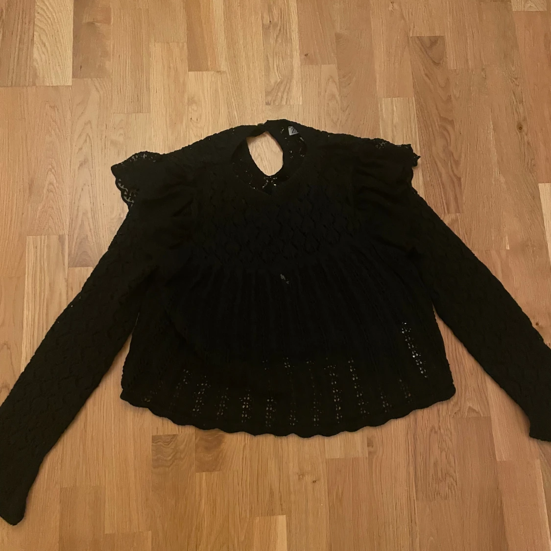 Svart spetsblus med volangdetaljer - 1