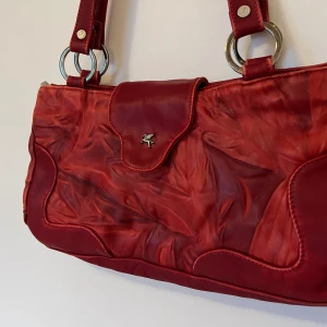 vintage röd läderväska - En röd läderväska i god kvalitet utan tydliga och synliga defekter. Rengjord och smord med ett tunt lager läderbalsam. Bilden i slutet är en jämförelse med ett A4 papper. Kontakta gärna vid frågor och funderingar!