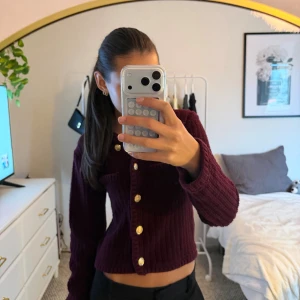 Fin vinröd cardigan med guldiga knappar  - En jättefin vinröd stickad långärmad cardigan från H&M med guldiga knappar (alla knappar går att knäppa med) Utgångs pris 190 kr