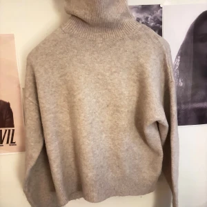 Beige polotröja från H&M - Säljer en beige polotröja från H&M i storlek S. Tröjan har en hög, ribbad polokrage och är stickad i ett mjukt material. Den har lång ärm och en relaxed, lite loose passform. Perfekt för lager-på-lager under höst och vinter.
