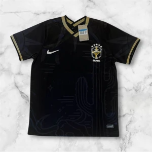 Svart Brasil Nike fotbollströja - Snygg svart Brasilien fotbollströja från Nike med gulddetaljer på krage och ärmslut. Tröjan har korta ärmar  och Brasil-logga med fem stjärnor på bröstet. Materialet är lätt och andas, perfekt för match eller träning.