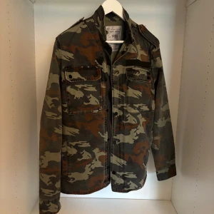 Camo field jacket från Zadig & Voltaire - Säljer nu en asfet Zadig camo fieldjacka/ overshirt. Jackan  har klassisk militärstil med axelklaffar, två stora bröstfickor och knäppning framtill. Storlek M och i jättebra skick. Pris kan diskuteras!