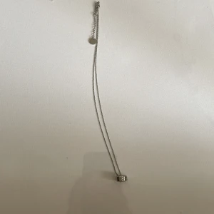  Halsband i silverfärg - Snyggt halsband från Carlheim med en rund, silverfärgad berlock i klassisk design. Kedjan är tunn och elegant, och berlocken har Carlheim-loggan ingraverad runt om. Perfekt för dig som gillar stilrena smycken med lyxig känsla.