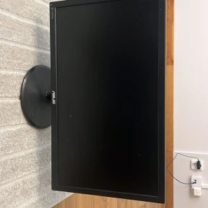 ASUS VS247 LCD Monitor - Snygg ASUS VS247 LCD-skärm med 24-tums Full HD-display och HDMI-ingång. Skärmen är i gott skick med mindre yttre slitage på baksidan. Perfekt för både arbete och spel. Stabil fot och tydlig bildkvalitet. Modell: VS247. Strömkabel och HDMI-port synliga.