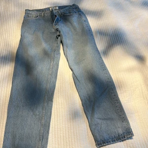 Ljusblå jeans från Pull&Bear - Säljer ett par ljusblå jeans från Pull&Bear med klassisk femficksdesign och rak passform. Jeansen har normal midja och är tillverkade i slitstarkt denimtyg. Perfekt för dig som gillar en enkel och clean look.