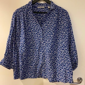 Blå leopardmönstrad skjorta Esprit XL - Snygg skjorta från Esprit i storlek XL med blått och vitt leopardmönster. Skjortan har en klassisk krage och är tillverkad i ett lätt bomullstyg som känns skönt mot huden. Perfekt för dig som gillar att sticka ut med coola mönster och färger.