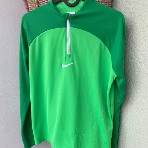 Grön Nike half zip tröja - Nike Dri-Fit hoodie i fräsch grön färg med vit logga på bröstet. använd några gånger,bra pris och kvalitet.