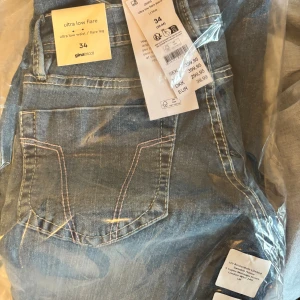 Ultra low flare jeans från Gina Tricot - Blå jeans med ultra låg midja och utsvängda ben från Gina Tricot. Dem är inte öppnade!