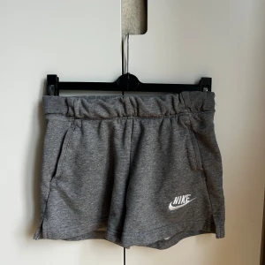 Grå shorts från Nike  - Säljer ett par gråa mjuka shorts från Nike. De har elastisk midja, och jag skulle säga att de är mjukis/träningsshorts! Det står att det är storlek m men jag skulle säga att de är mer en xs/s kanske tillomed en xxs! Skriv gärna ifall ni vill ha fler bilder på shortsen!💕