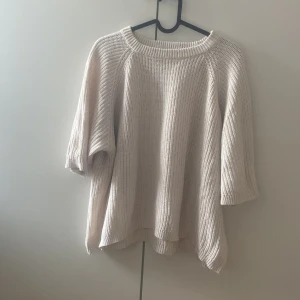 Beige stickad tröja från 157 XS - Säljer en beige stickad tröja från 157 i storlek XS. Tröjan har en rund halsringning och trekvartsärmar, vilket ger en chill och avslappnad vibe. Perfekt för lager-på-lager och passar till jeans eller kjol. Ribbstickad struktur för extra mysfaktor.