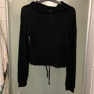 Svart ribbad hoodie från Gina Tricot - En svart hoodie i tunt material från Gina Tricot. Materialet är ribbat och mycket tunnare än en vanlig hoodie så den här kan man ha även på sommaren. Den är testad men aldrig använd. Helt ny. Jag säljer den eftersom den är för liten för mig. Om man vill ha bilder med tröjan på kan man skriva till mig. Pris kan diskuteras.
