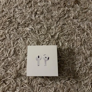 AirPods 4 - Helt nya Apple AirPods 4 i originalförpackning. Trådlösa hörlurar med laddningsetui, designade för hög ljudkvalitet och smidig anslutning till Apple-enheter. Förpackningen är obruten och produkten är oanvänd, perfekt skick.