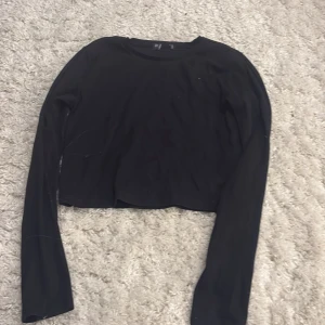 Svart croppad långärmad topp, lappen är avklippt men den är i storlek s - Svart långärmad topp från S i storlek M. Modellen är croppad med rund halsringning och har en clean, enkel look som funkar till många stilar. Materialet känns mjukt och stretchigt, perfekt för dig som gillar bekväma och stilrena plagg.