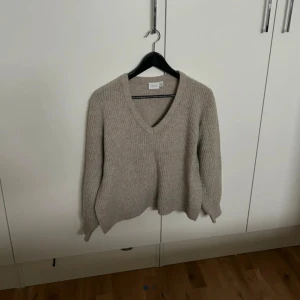 Ribbstickad V-ringad tröja från Vila - Två mysiga ribbstickade tröjor från Vila med V-ringning och långa ärmar. En i beige och en i mörkblått, båda med relaxed fit och mjukt material. Perfekta för lager-på-lager under höst och vinter.