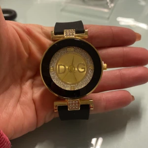 Supersnygg klocka  - Ny klocka med svart rem och guldiga detaljer. 