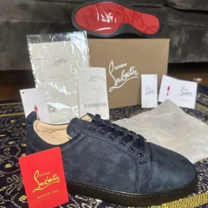 Mörkblå sneakers från Louboutin - Snygga mörkblå sneakers från Christian Louboutin i mjuk mocka med klassisk röd sula och rund tå. Skorna har snörning och en stilren design som passar perfekt för dig som gillar exklusiva märken och italiensk kvalitet.