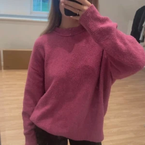 Mysig rosa stickad tröja - Jätte mysig och skön oversize stickad tröja från pull&bear som inte kommer till användning. Den är rosa med små inslag av lila. Endast använd ett fåtal gånger. Den är liiite nopprig då den bara har hängt i garderoben, men det är inget man tänker på när man har på sig den💜🩷