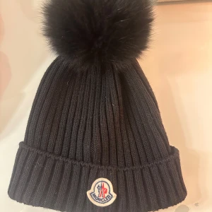 Moncler mössa - Äkta moncler mössa, storlek m (junior) passar alltså vuxna med. Inga defekter eller dofter. Pälsbollen är äkta. Nypris 2500 kr mitt pris 1000kr. 