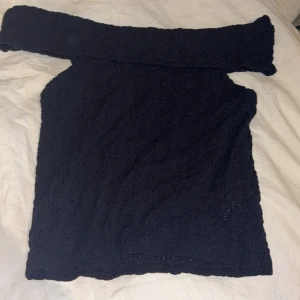 Svart offshoulder topp från Kappahl - Säljer en svart offshoulder topp från Kappahl i storlek 146/152. Toppen har en snygg struktur i tyget och är ärmlös med bred volangkant över axlarna. Perfekt för dig som gillar en stilren och trendig look. Aldrig använt 